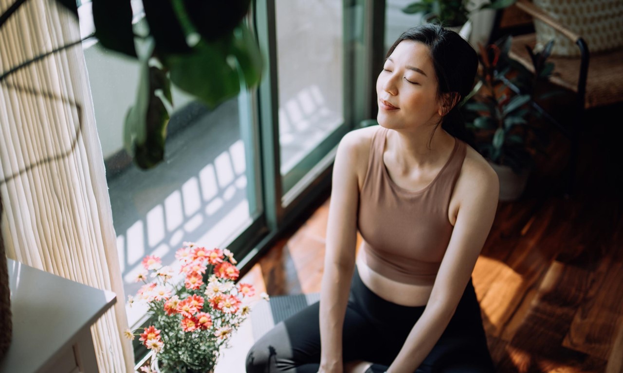 A woman sitting on the floor with eyes closed