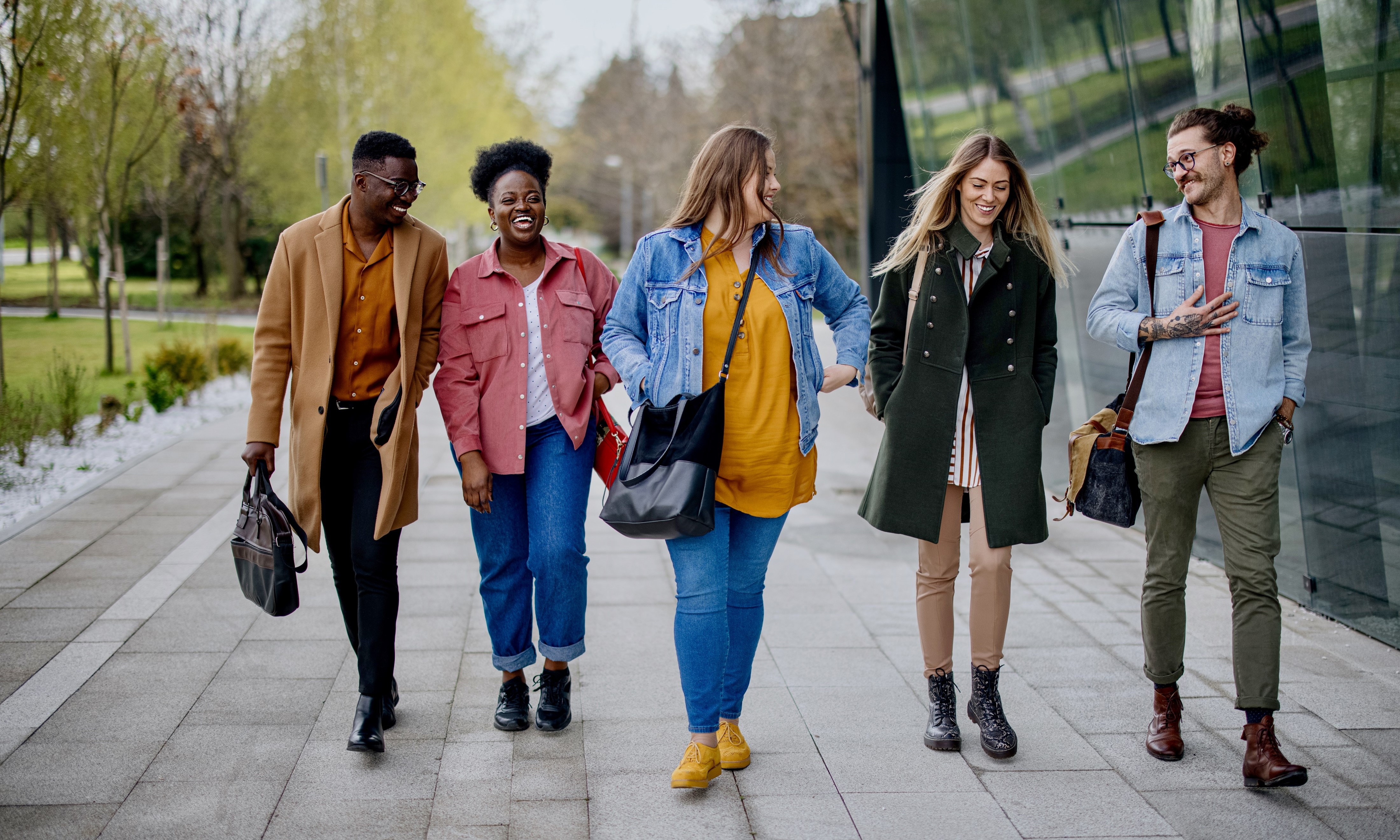 A group of people walking on a sidewalk