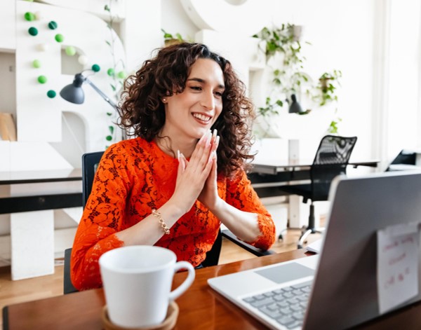 A person smiling at a laptop