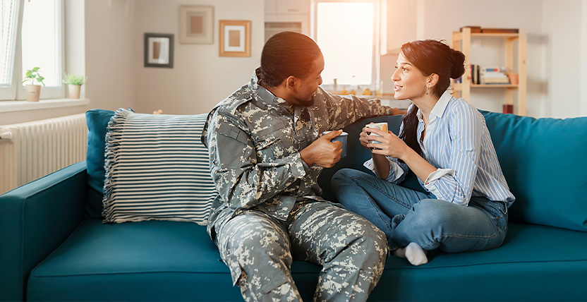 a husband and wife talking on the couch
