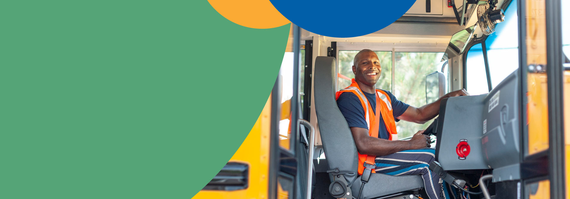 A male school bus driver sits comfortably in the driver's seat, prepared to greet and assist children as they prepare to board the bus