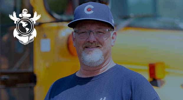 Veteran school bus driver standing in front of the bus