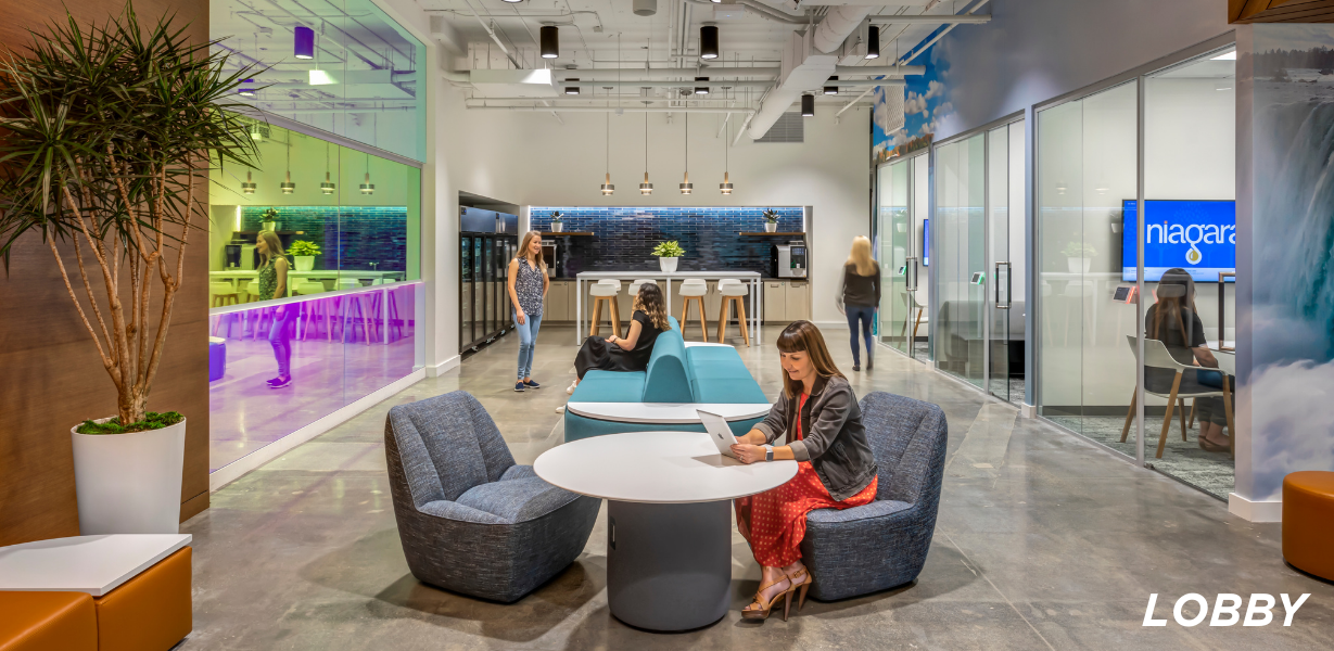Image of a long room with desks and a couch 