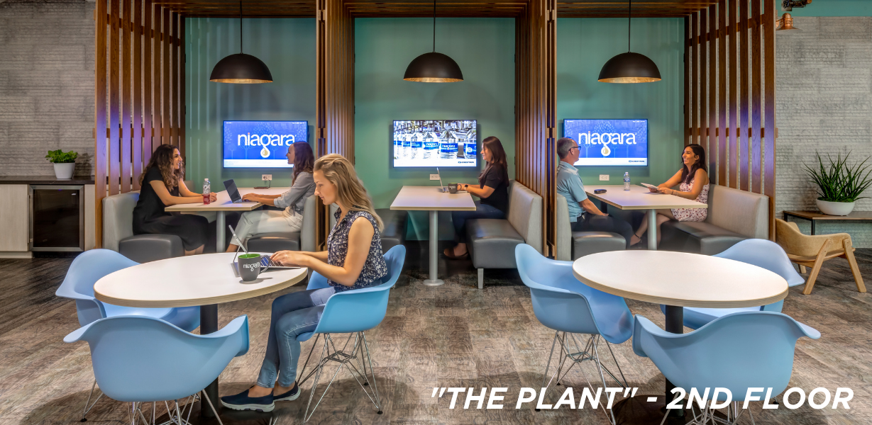 Niagara team members working at tables and booths on the second floor of HQ 