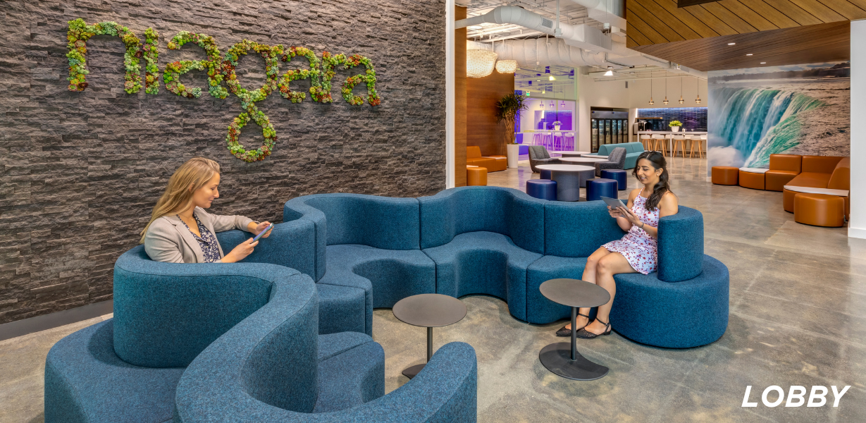 Image of Niagara lobby; blue couch in a "squiggly" shape in front of a cement wall with "niagara" written in plants 