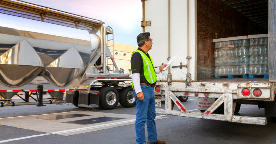 Man taking inventory of a truck full of pallets of Niagara water bottles