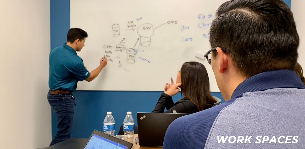 Man writing on a white board in front of a room full of people