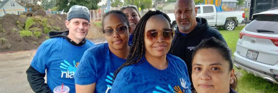 Niagara team members smiling before rebuilding an elementary school playground