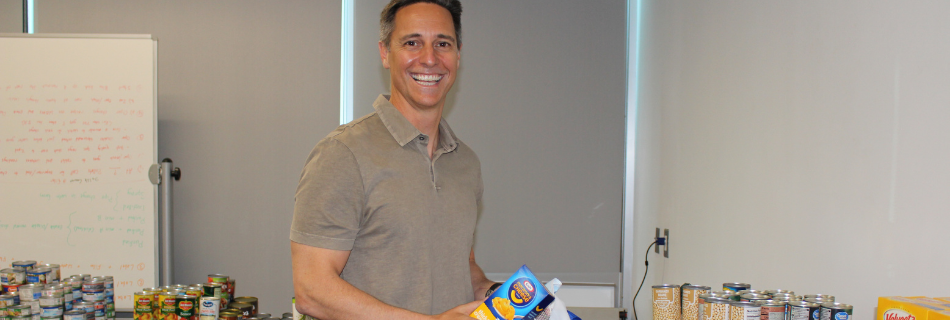 Andy Peykoff II smiling while placing food into boxes 