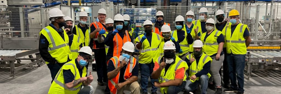 Niagara team members smiling in front of their first shippable pallet