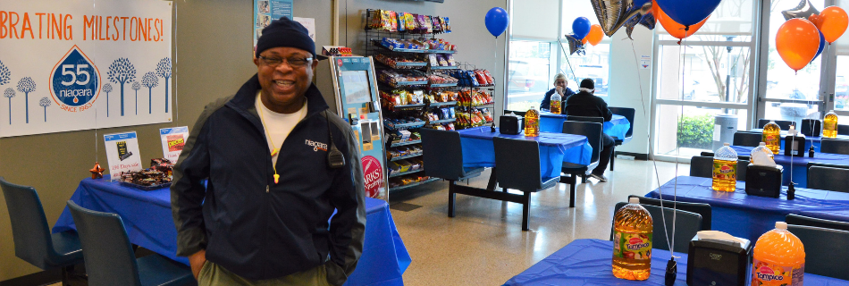 Man smiling in a room with balloons and party supplies setup