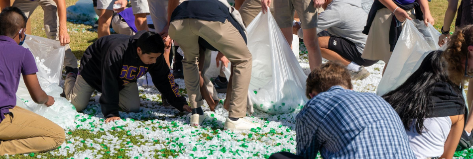Men and women collecting bottle caps and placing them into bags