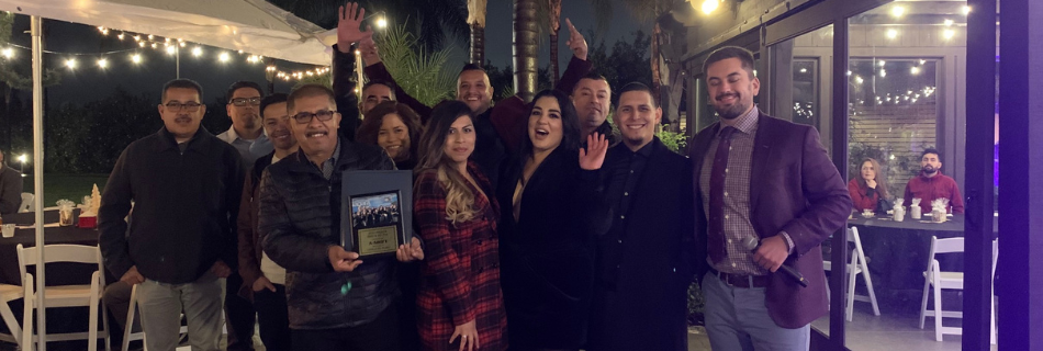 Niagara team members smiling in a restaruant with a plaque in-hand