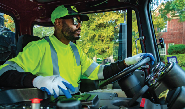 Black male end user driving refuse collection vehicle