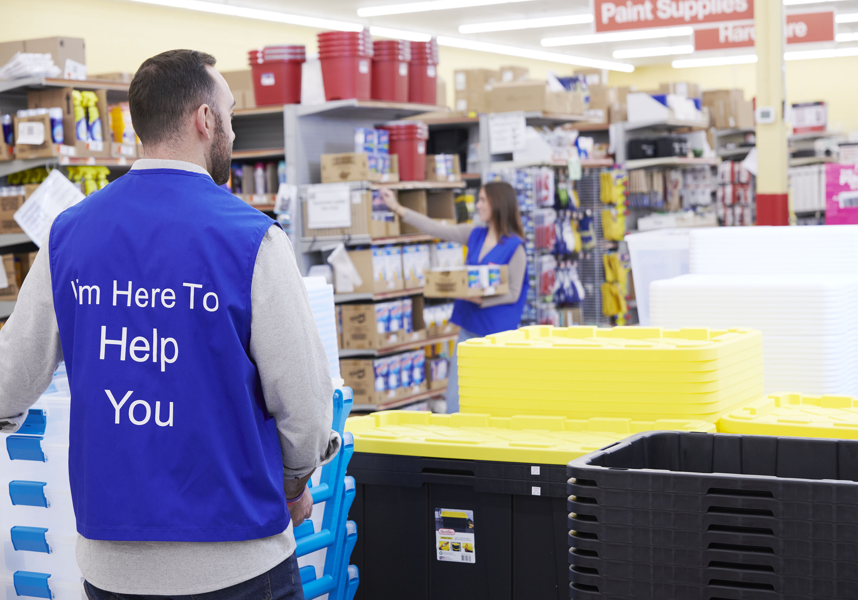 Store Associate stocking and organizing the store with blue vest on
