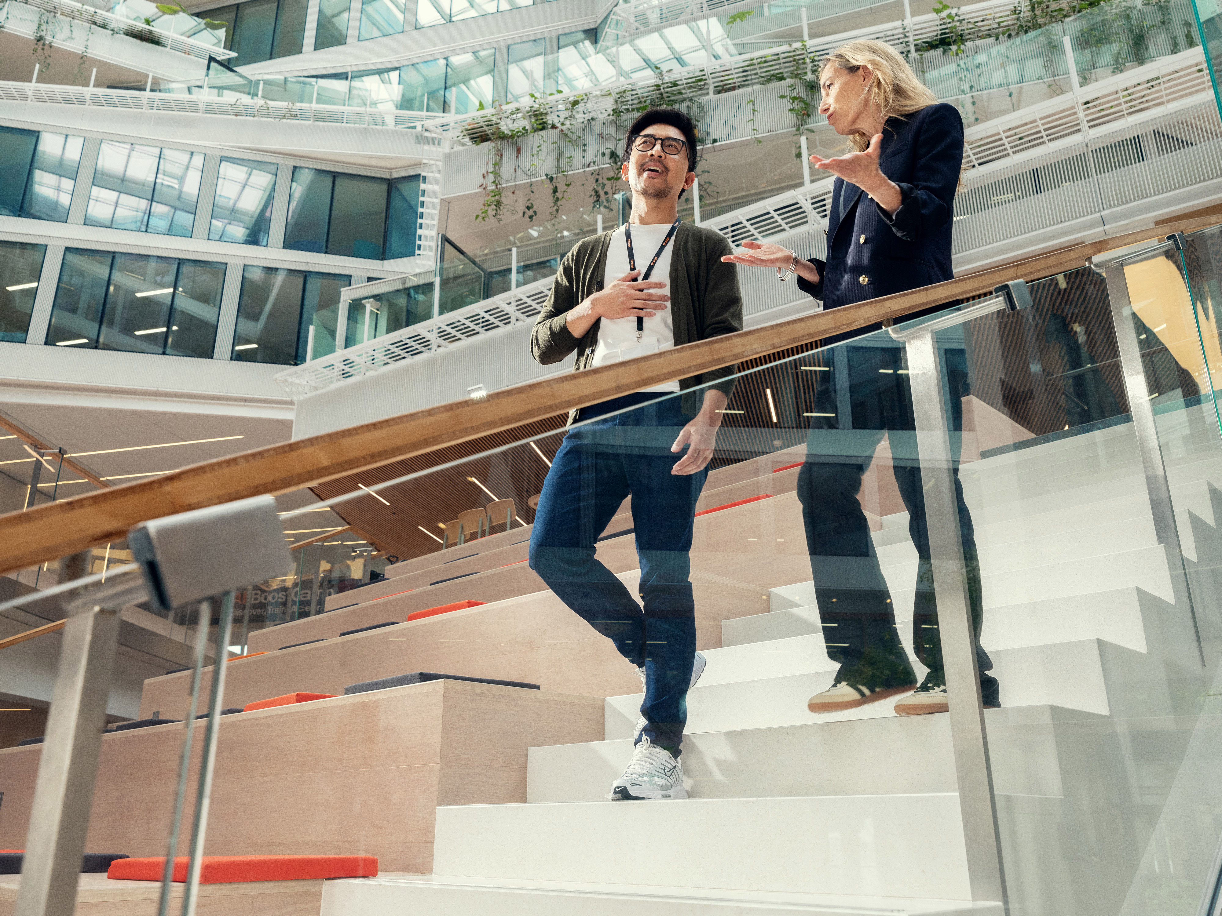 Two Orange employees walking down the stairs