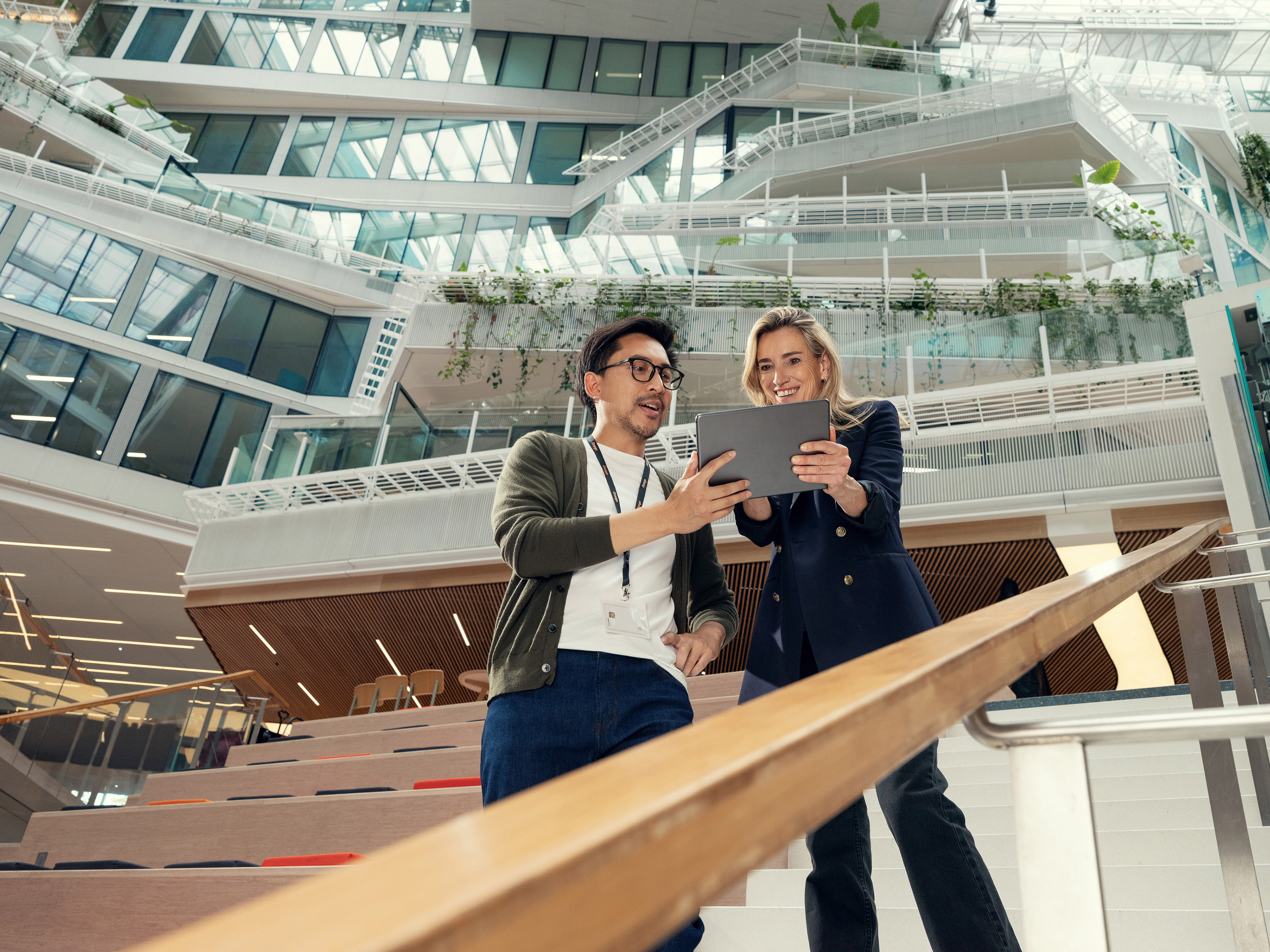 An employee showing his work on a screen to his Orange manager