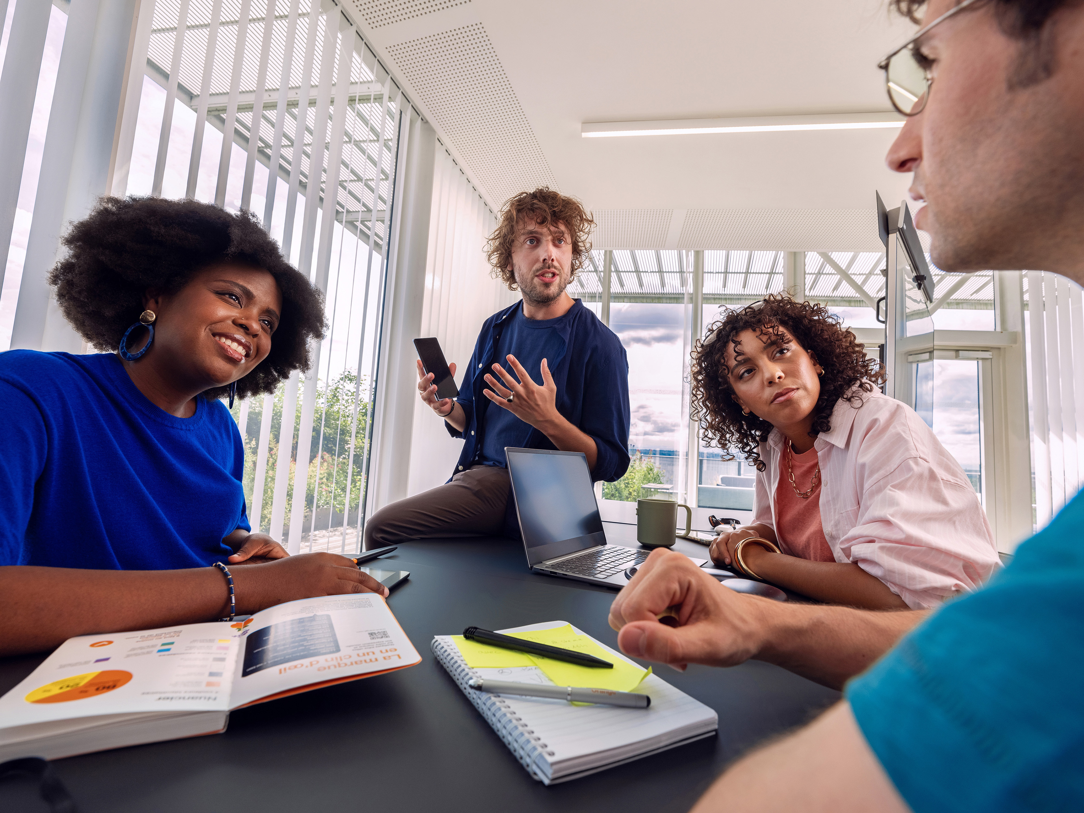 Orange colleagues enthusiastically discussing in a meeting.