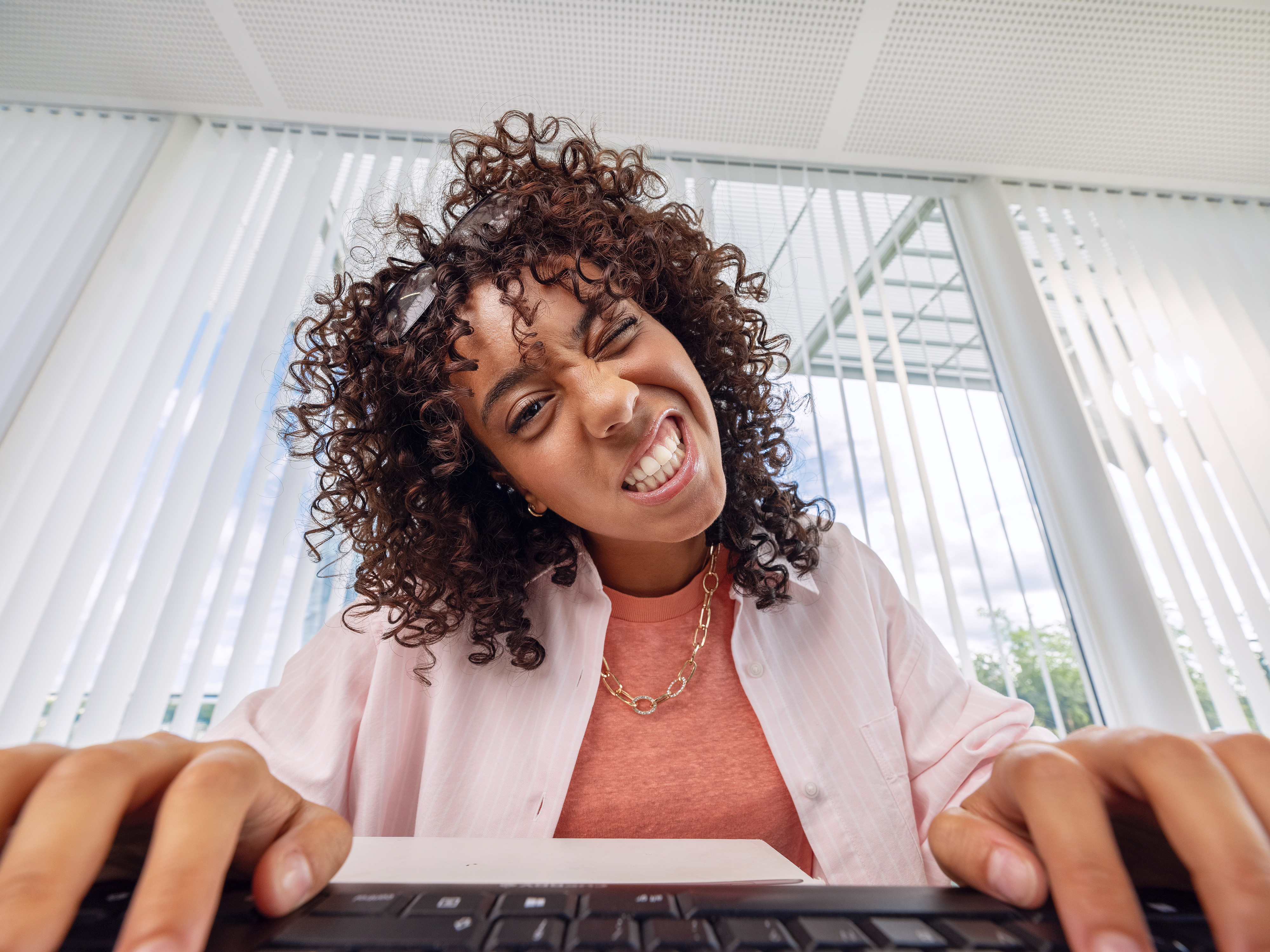 A young Orange employee making a funny face at her computer