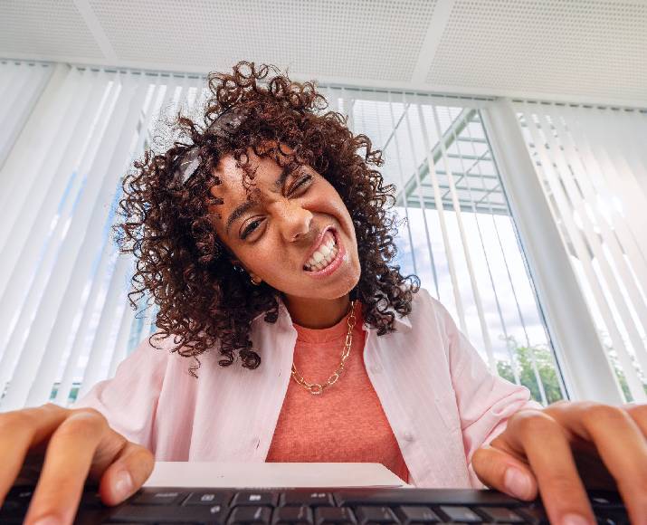 A young Orange employee making a funny face at her computer