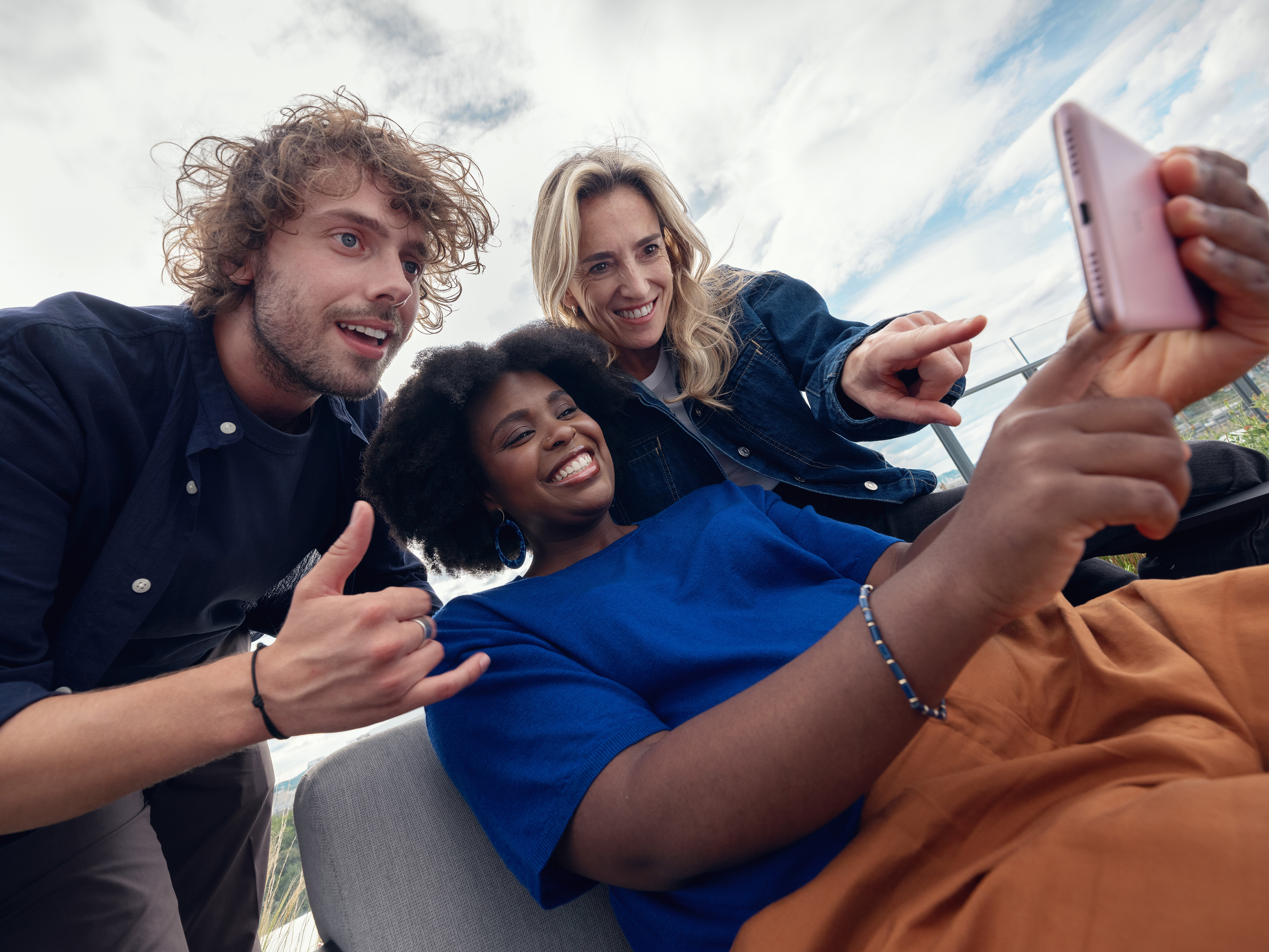 Several Orange colleagues looking at a video on a phone.