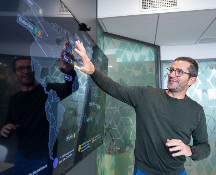 An Orange Cyberdefense employee looking at a world map on a screen