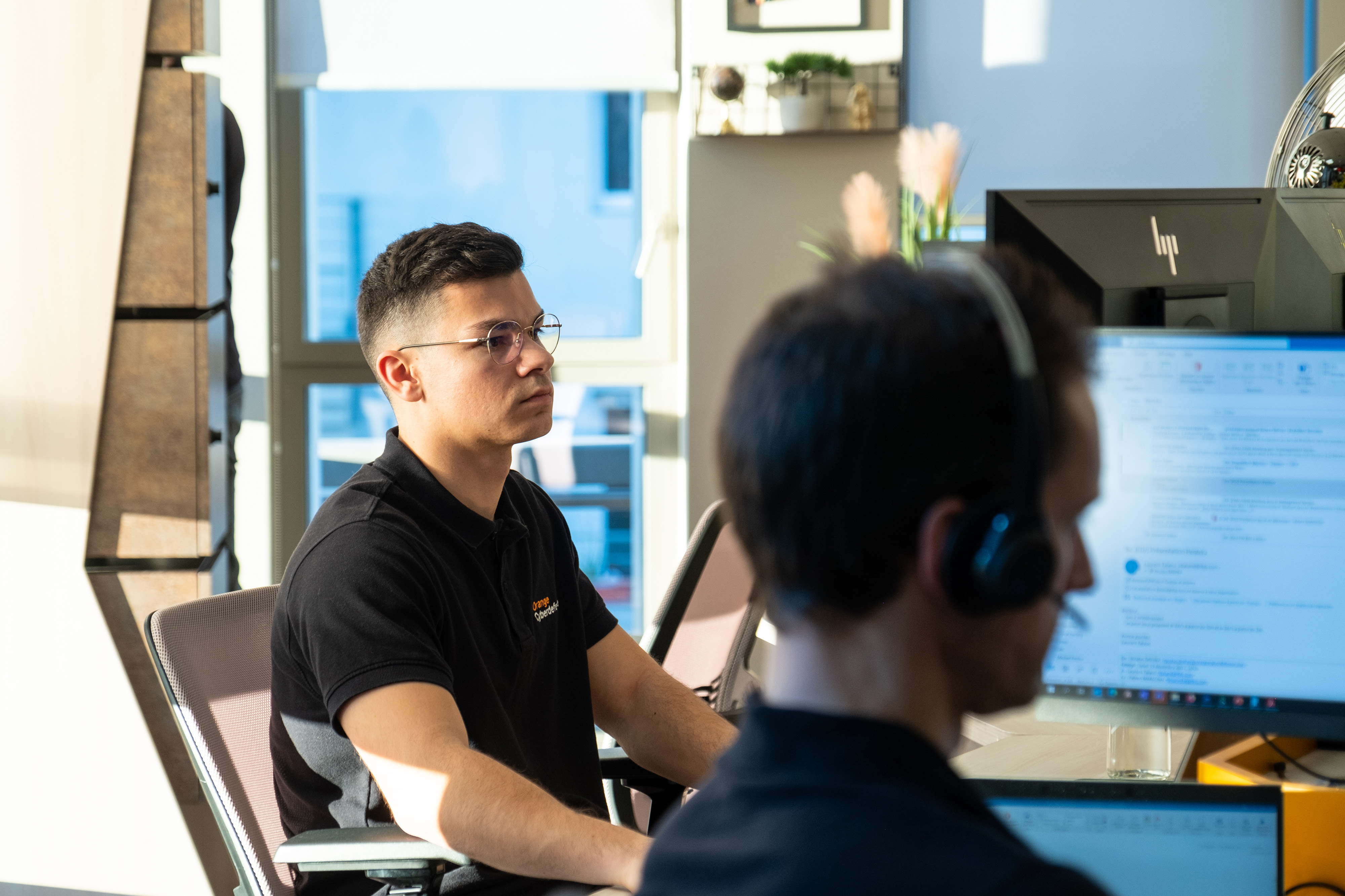 2 Orange cyberdefense employees working at their desks
