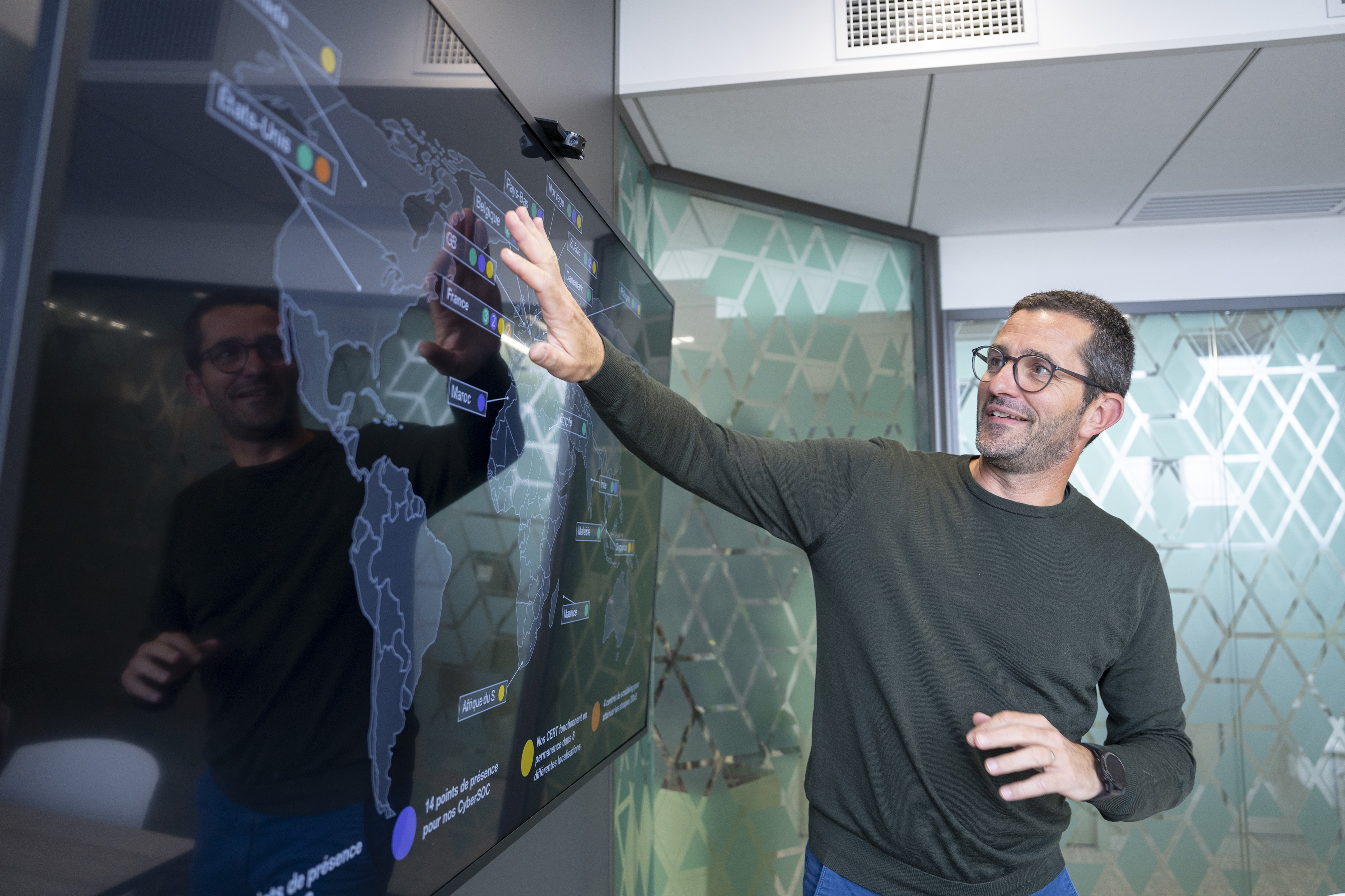 An Orange Cyberdefense employee looking at a world map on a screen