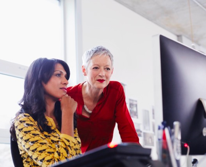Two Orange female employees focused on a screen