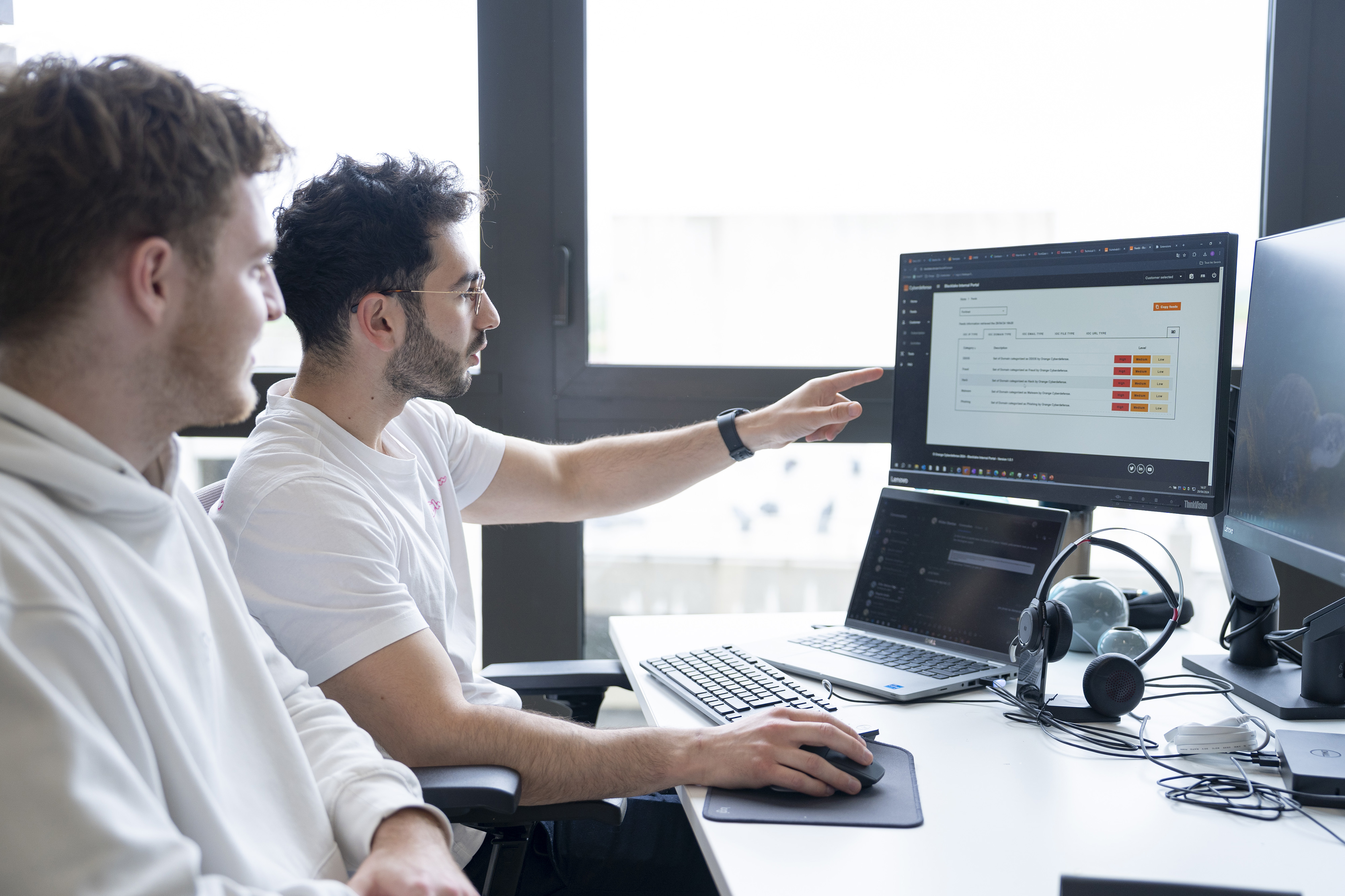 Orange employee analyzing data on screen