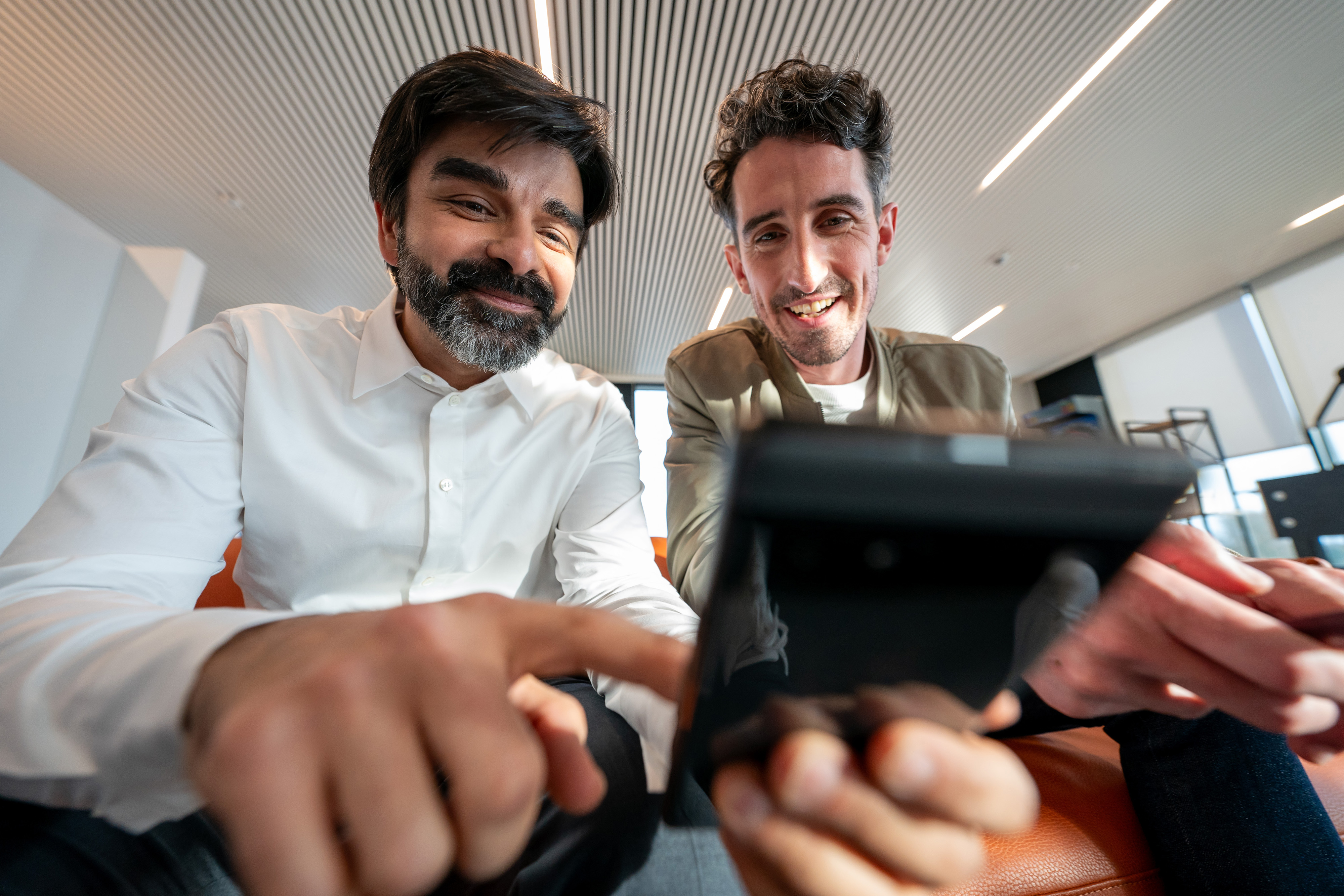 Two Orange employees looking at smartphone