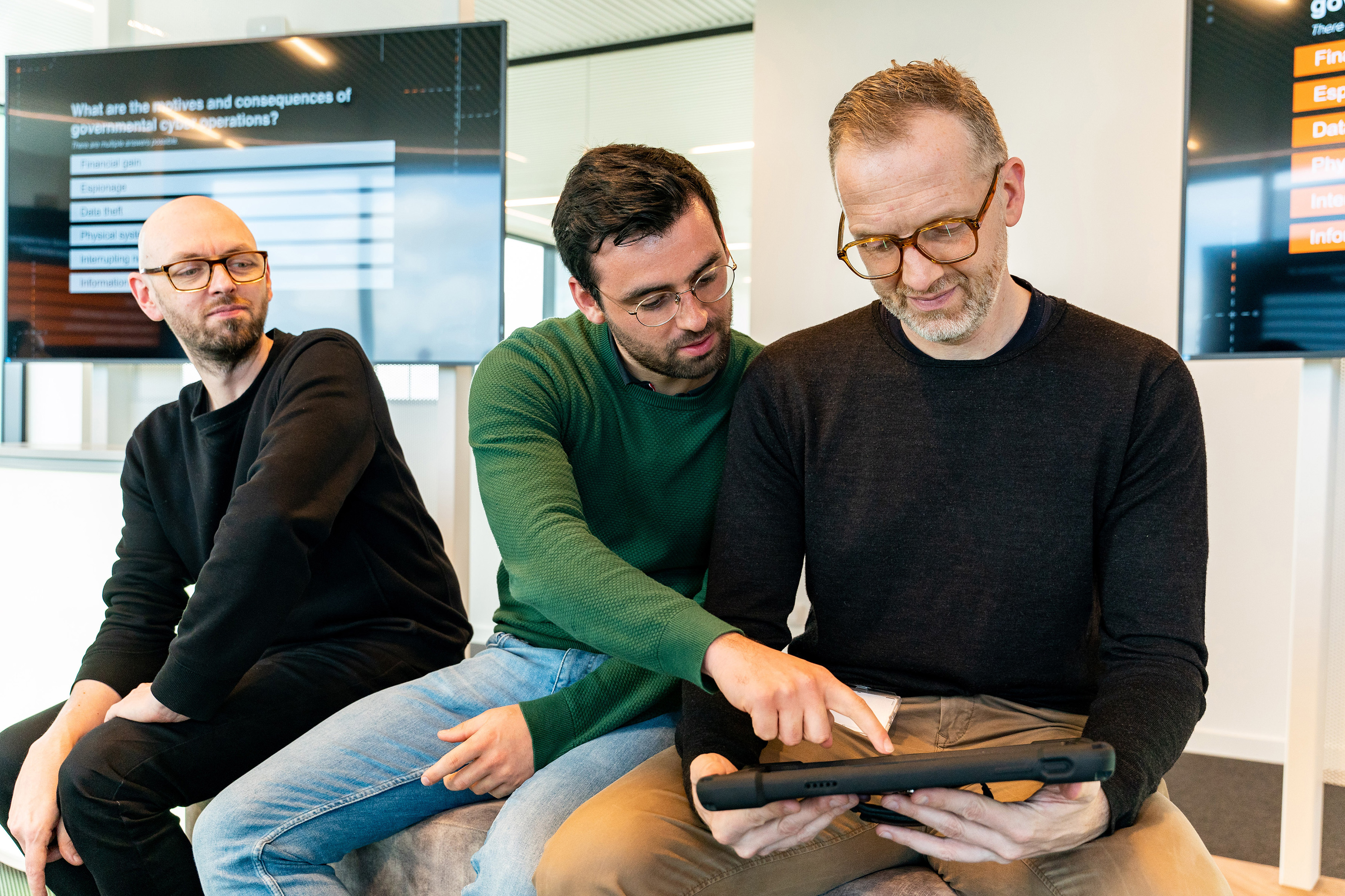 Two Orange employees using a tablet