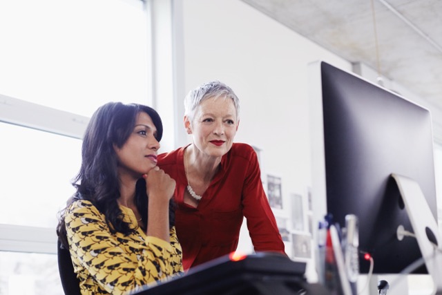 Two Orange female employees focused on a screen
