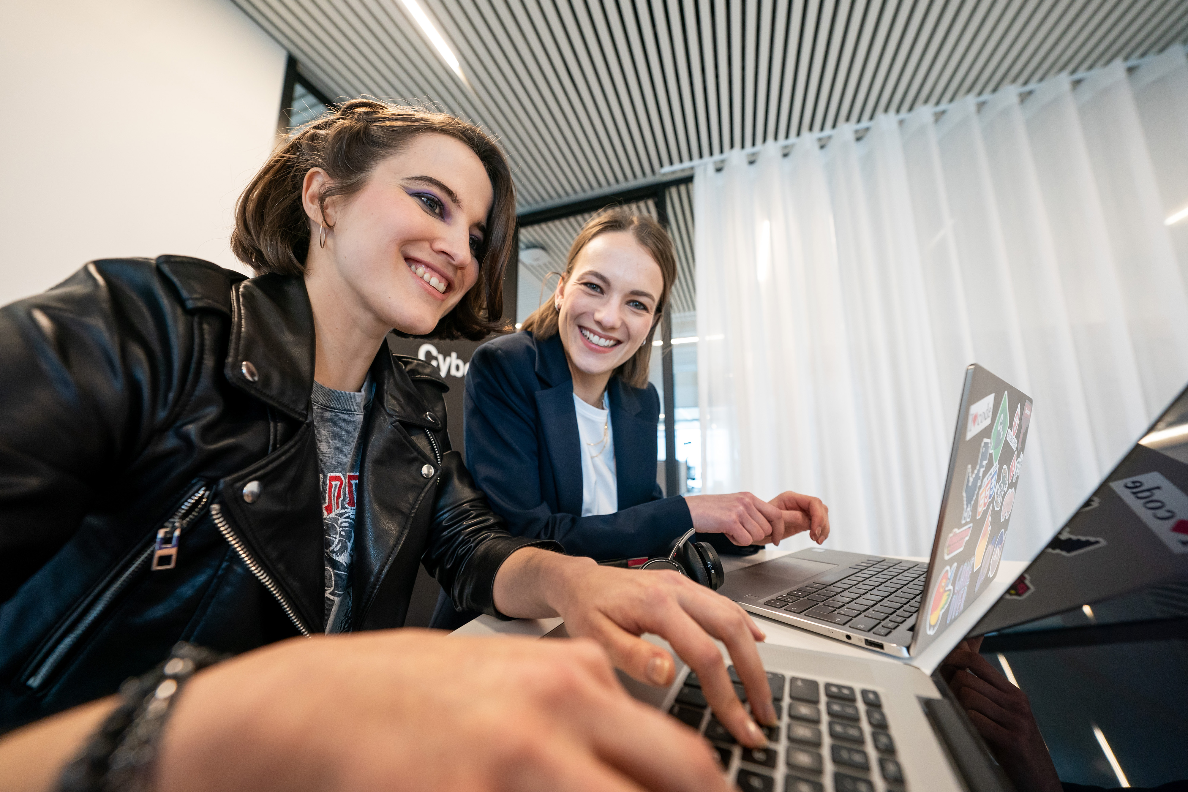 Two Orange colleagues working on laptops