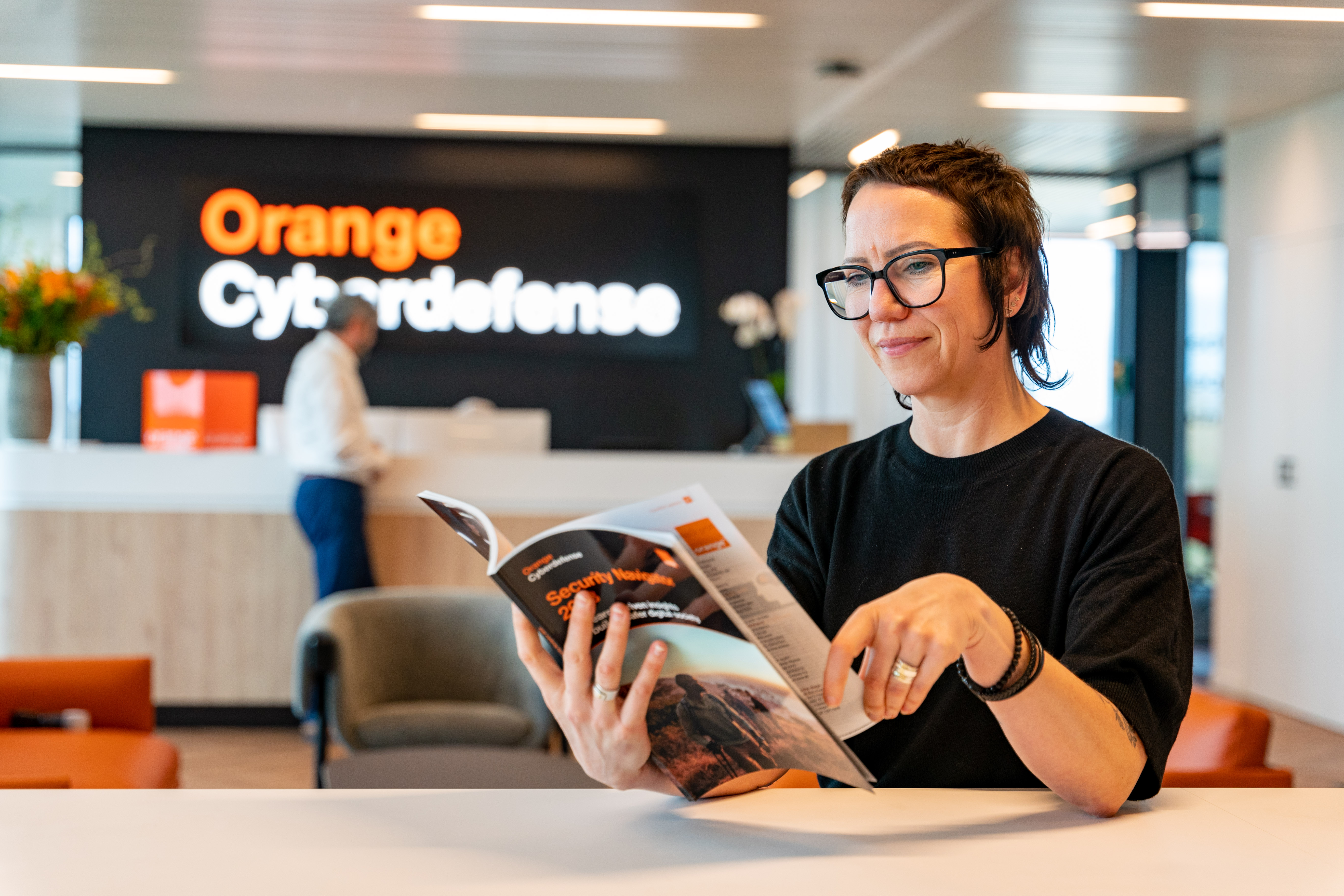 Colleague reading Orange Cyberdefense brochure