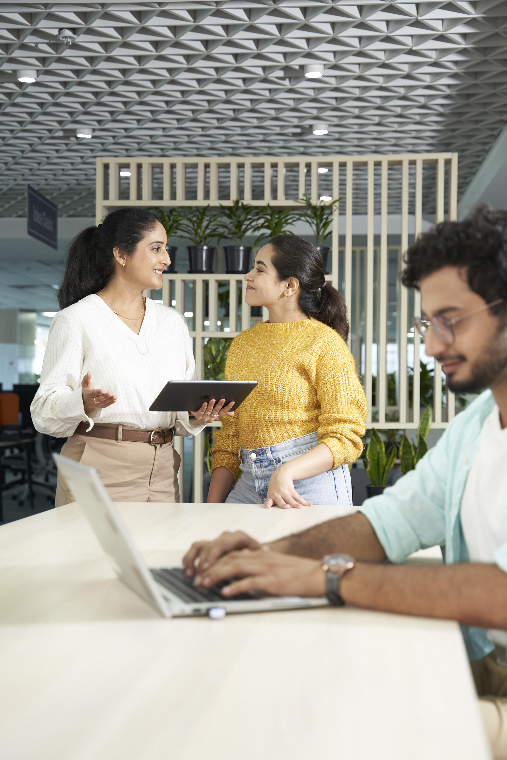 Three Orange employees discussing in the office
