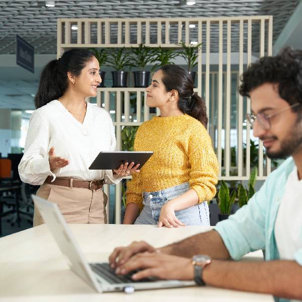 Three Orange employees discussing in the office
