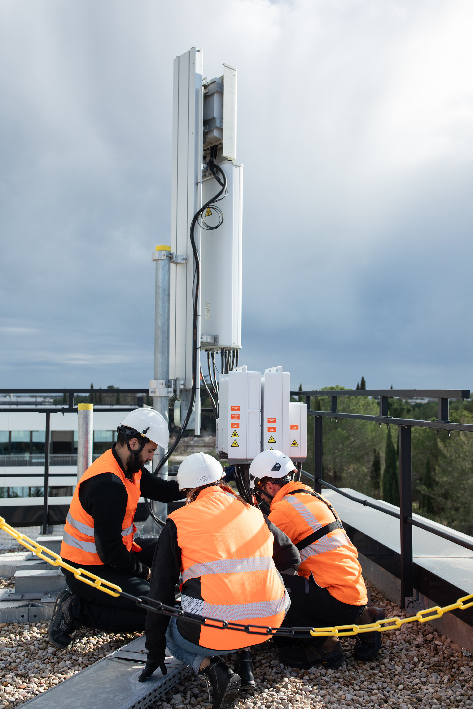 A team of Orange employees working on an antenna