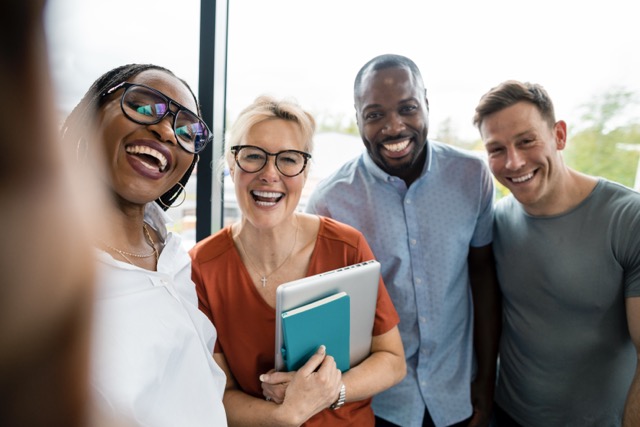 Smiling Orange team posing together at the office
