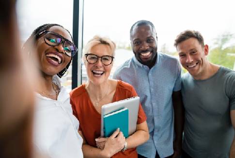Smiling Orange team posing together at the office