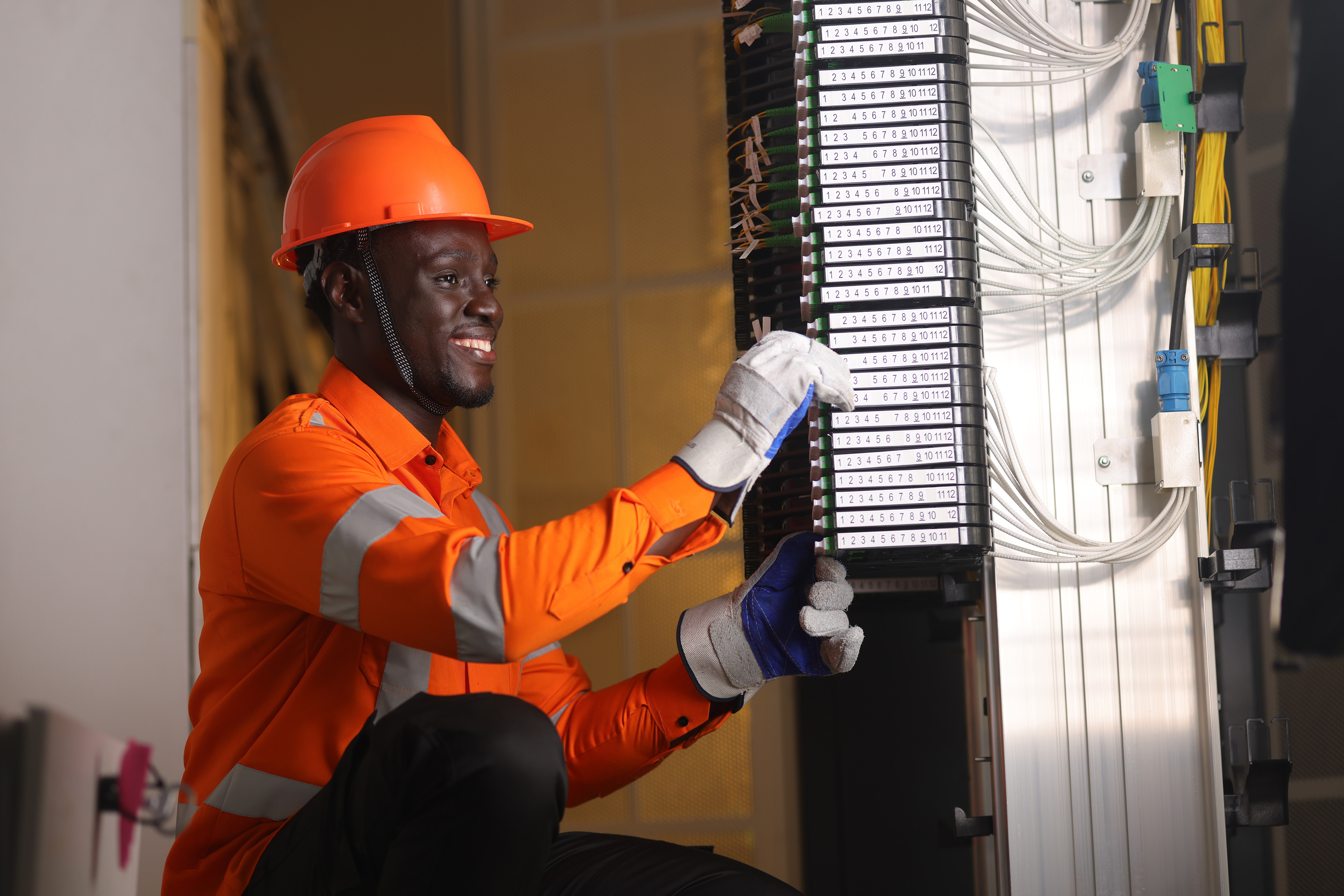 Orange engineer checking servers in a server room
