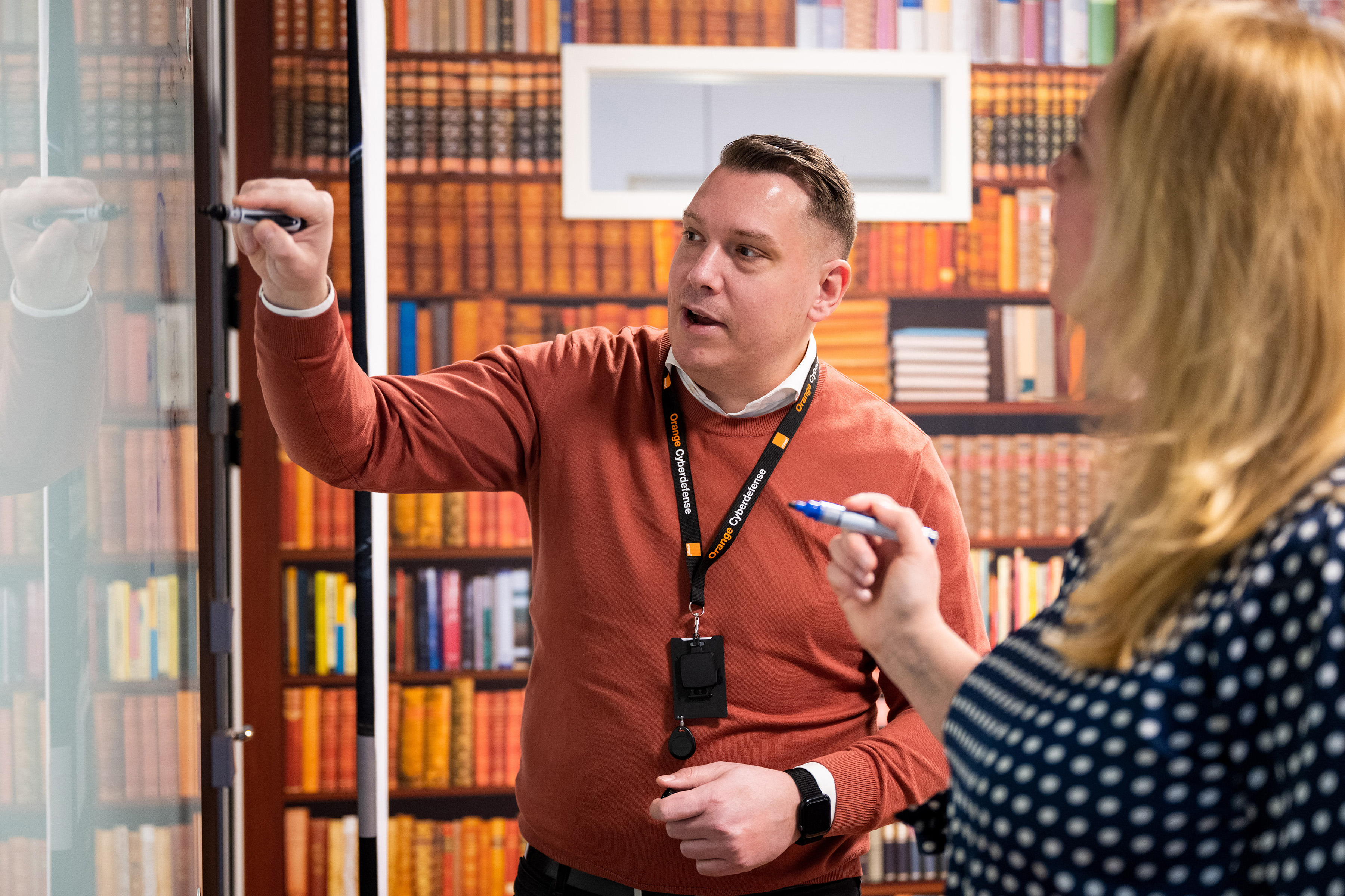 Orange manager training a colleague