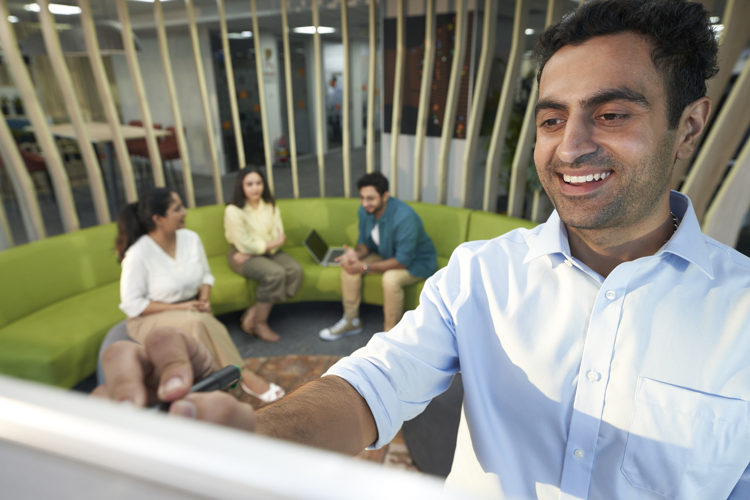 Orange manager writing on a whiteboard during a meeting