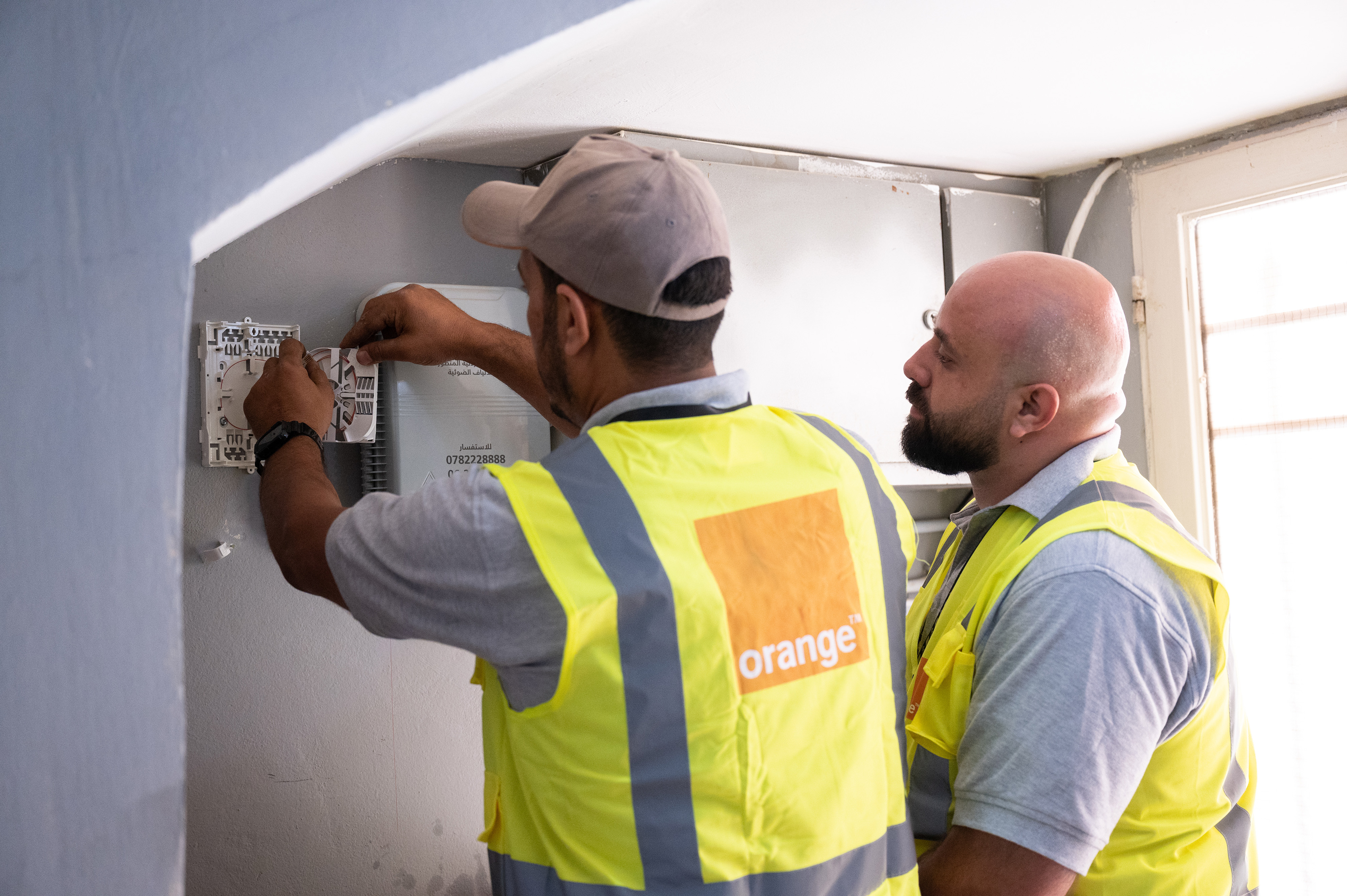 Orange technician installing a fiber optic cable
