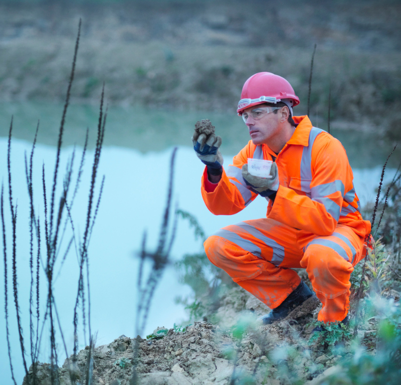 person outside looking at item from lake
