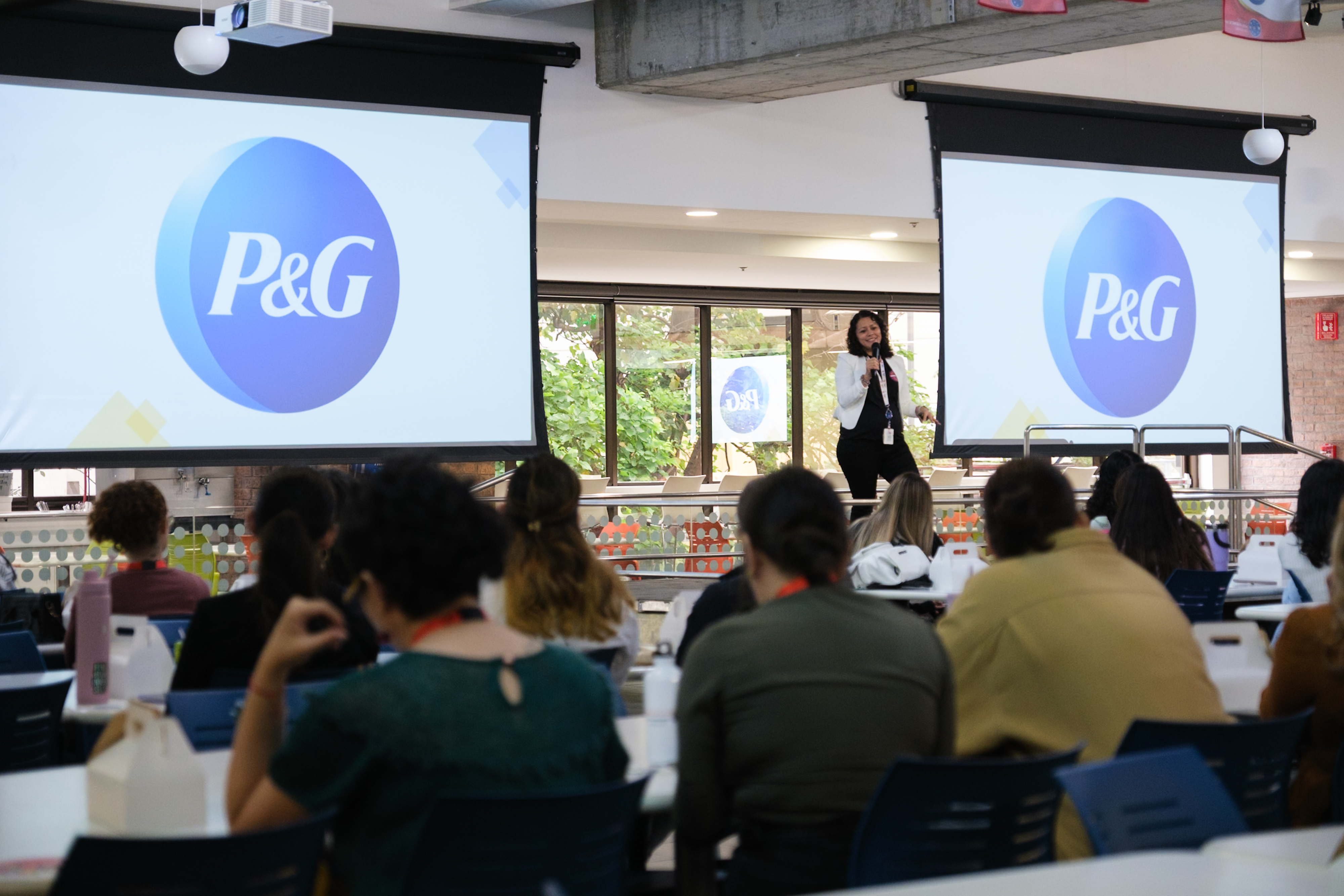 IMAGE OF AN EMPLOYEE GIVING A TALK ABOUT P&G TO MAKE US KNOWN