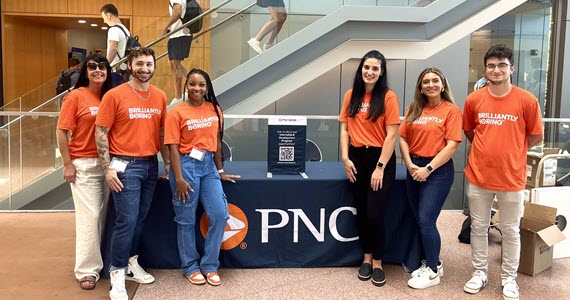 PNC interns grouped together building a trike.