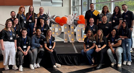 PNC Campus Recruiting team standing in a group around lighted letters that spell "PNC"
