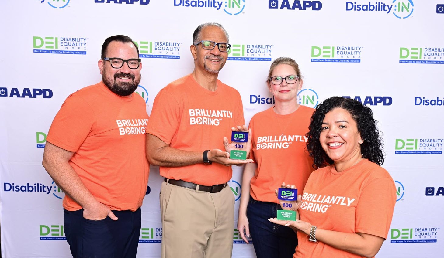 A group of three PNC employees standing next to each other and smiling at the camera. They are standing in front of a banner that says "Add Value, Feel Valued"