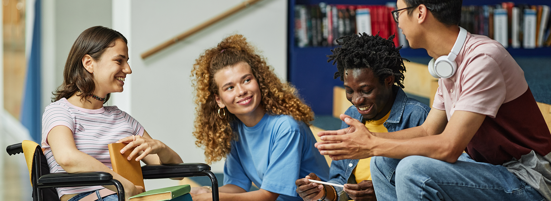 Four students talking in a library.